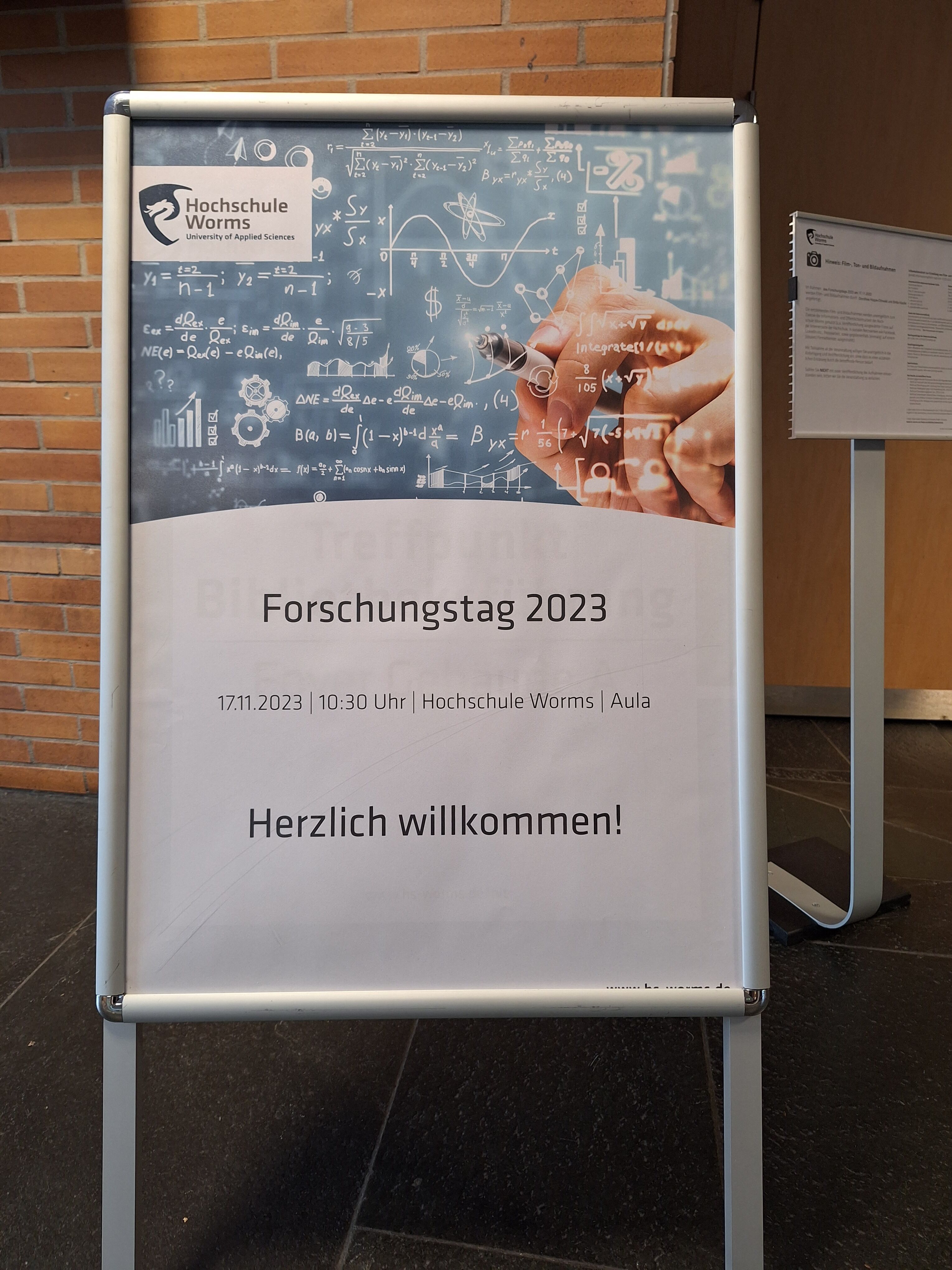 Aufsteller mit Plakat zur Begrüßung der Gäste des Forschungstags 2023 an der Hochschule Worms