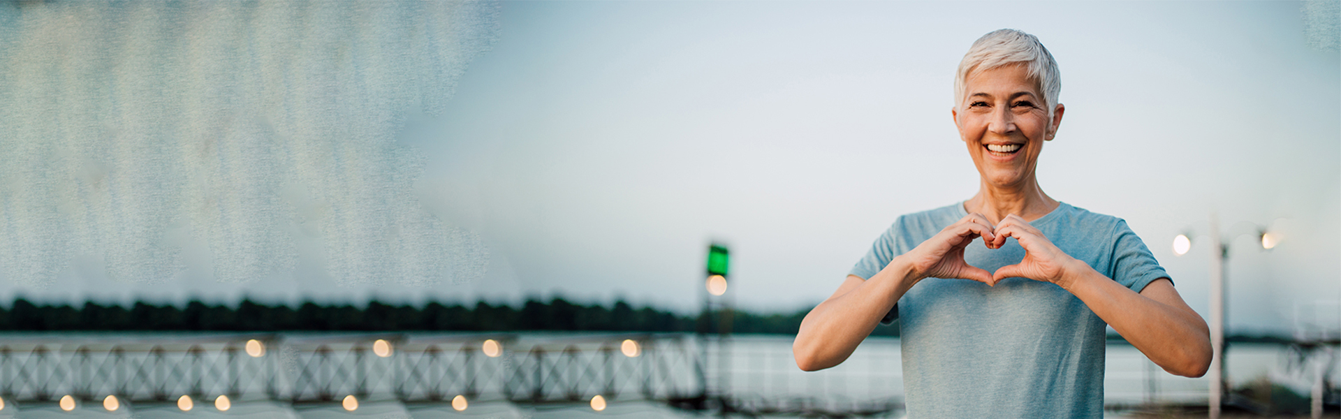 Forschung zum Megatrend Gesundheit: Eine Frau lächelt in die Kamera und formt mit Ihren Händen ein Herz.