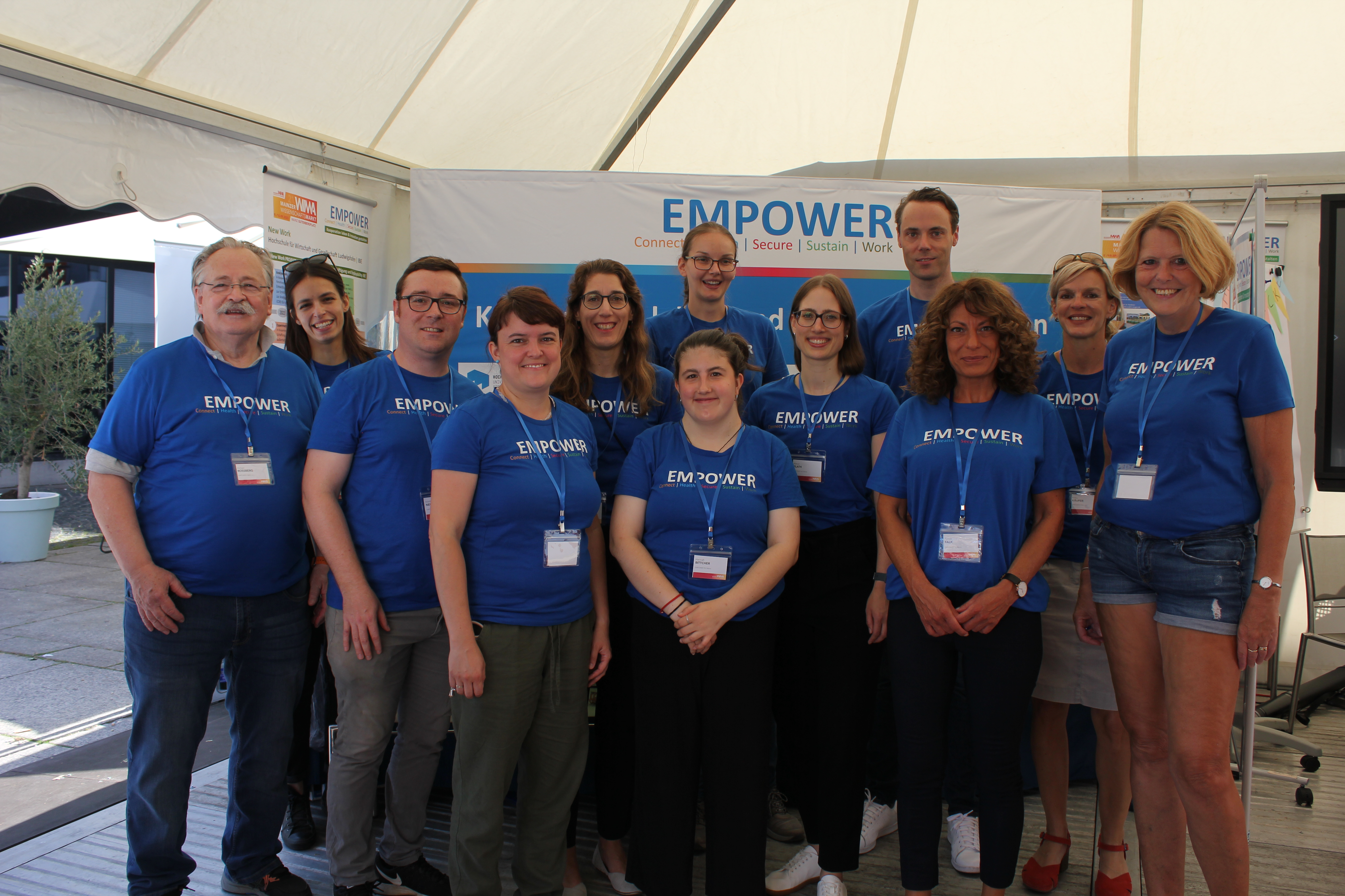 Gruppenfoto des EMPOWER-Teams vor dem Stand auf dem Wissenschaftsmarkt in Mainz